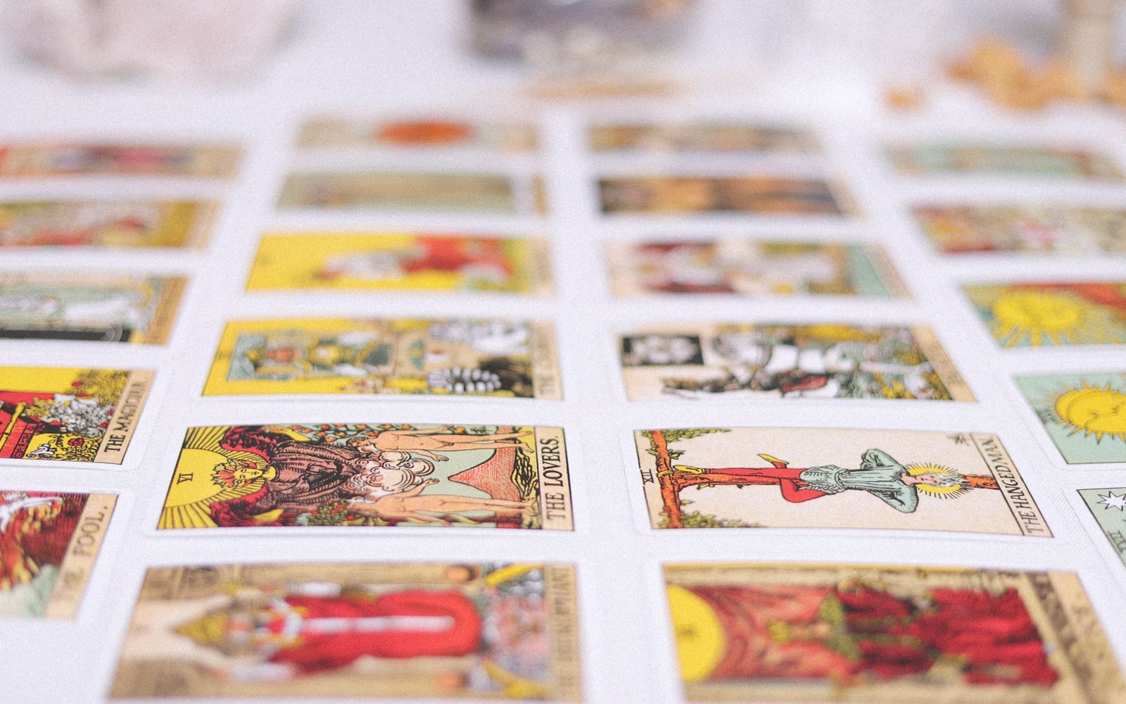 A full printer's press sheet of tarot card faces, uncut, laid flat under bright even light showing ink registration marks at the margins